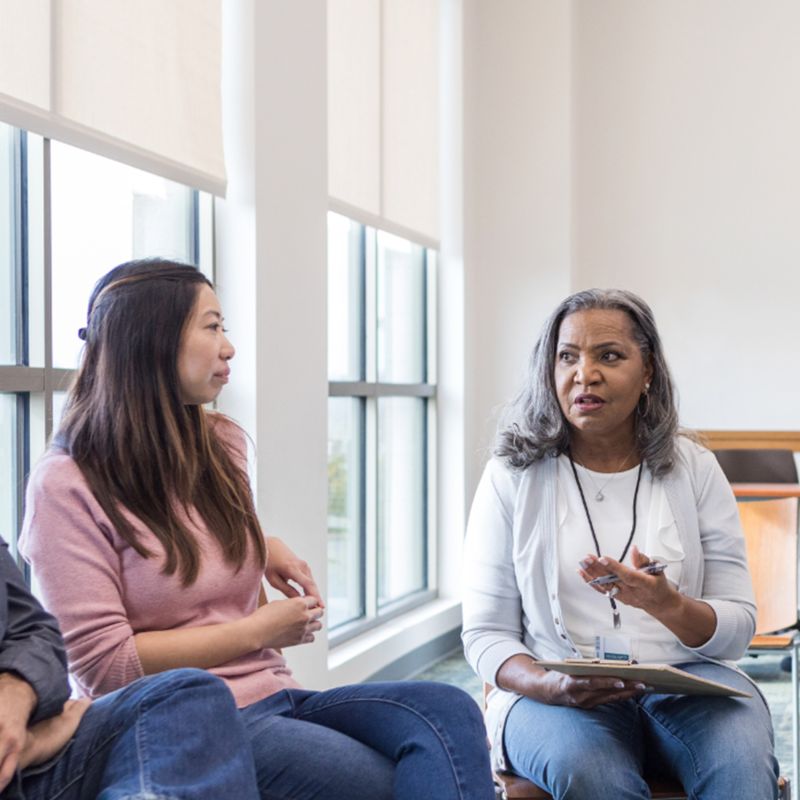 Two woman siting in an open office space participating in a focus group.