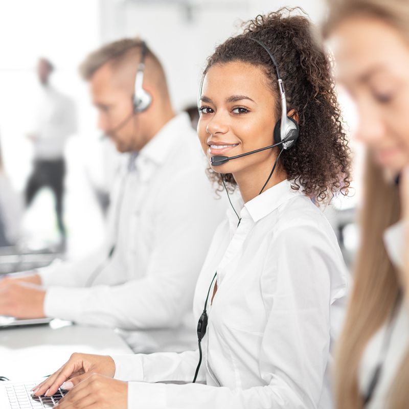 Woman working in a call centre smiling at the camera 