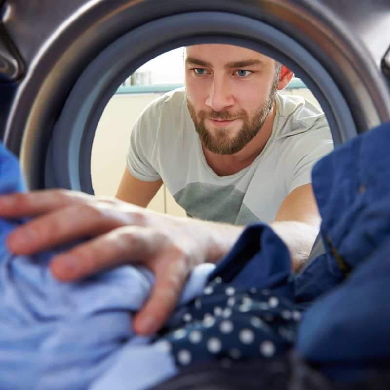 Man putting clothes into a washing machine