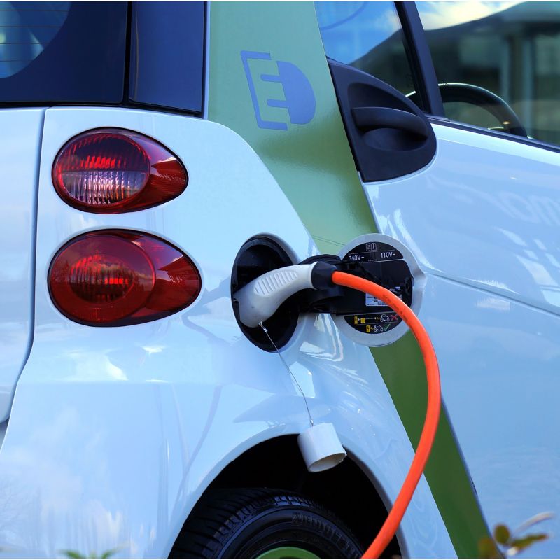 a charger plugged into an electric vehicle at a charging station