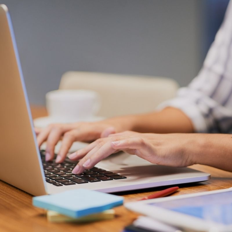 A person typing on a laptop computer