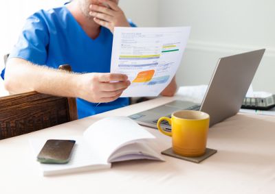 A person looking at an energy bill with their hand over their mouth suggesting concern