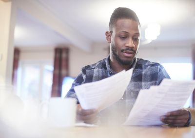 Man looking a numerous paper documents in both hands
