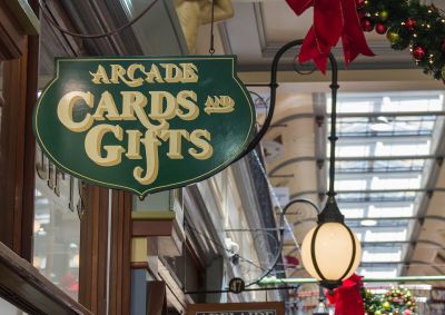 A shopping arcade showing a business sign hanging from one of the shops