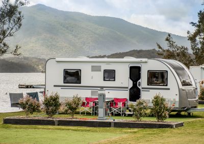A caravan set up by a lake in a caravan park