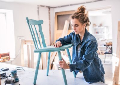 Woman fixing a chair in a home work studio
