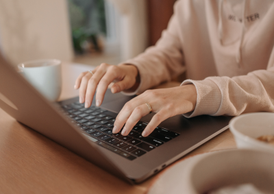 Close up of a woman typing on her laptop.
