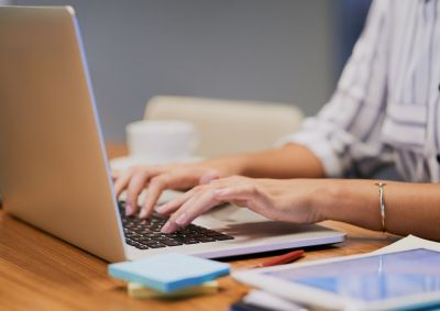 A person typing on a laptop computer