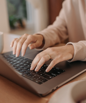 Close up of a woman typing on her laptop.